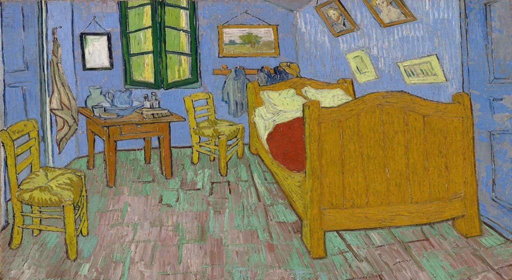 El dormitorio en Arlés de Vincent van Gogh: una habitación con paredes azules, una cama de madera amarilla, dos sillas y cuadros colgados.